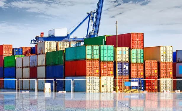 Stacked shipping containers under a quay crane.