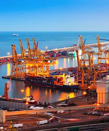 A port at night with cranes lit over the water.