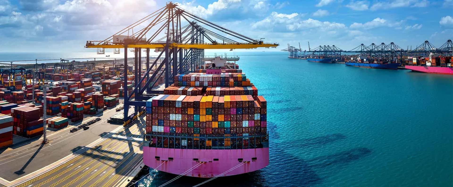 A loaded container vessel at its berth, seen from the stern.